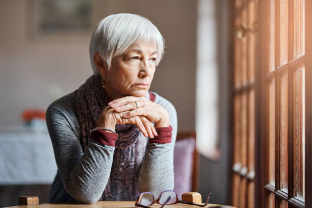 Any minute now... Shot of a senior woman looking thoughtful in a retirement home hopelessness stock pictures, royalty-free photos & images