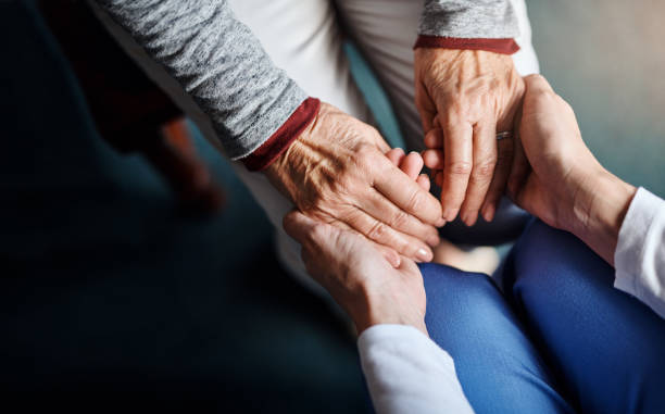 you're not alone in this - holding hands human hand senior adult consoling imagens e fotografias de stock