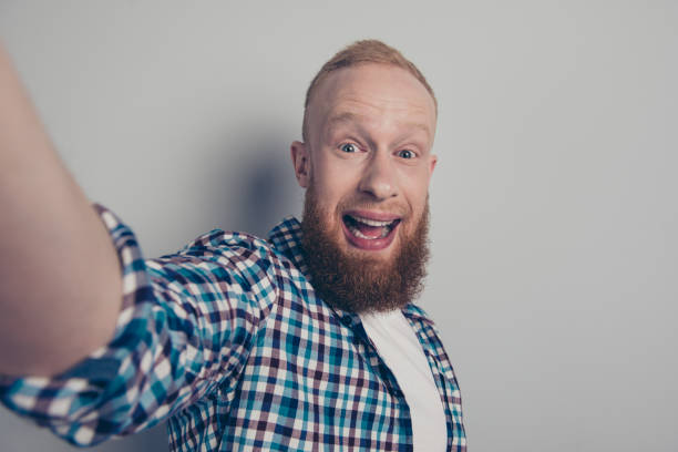 istock Attractive handsome man take photo on cellular stand isolated on light gray background look at camera make beaming toothy smile 1091766896