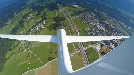 Aerial view of glider flying in sky over landscape.