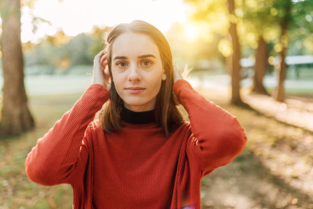 Portrait of attractive young woman in the park. Caucasian female looking at camera with big smile on her face.