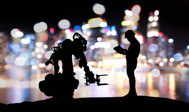 Industry 4.0 technology , artificial intelligence trend concept. Silhouette of engineer man control to heavy automation robot arm machine. Bokeh flare light effect with building background. Industry 4.0 technology , artificial intelligence trend concept. Silhouette of engineer man control to heavy automation robot arm machine. Bokeh flare light effect with building background. computer aided manufacturing photos stock pictures, royalty-free photos & images