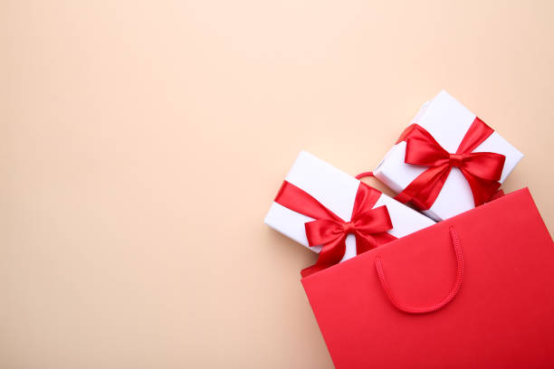 istock Gift boxes in red paper bag on beige background, shopping concept 1091794328