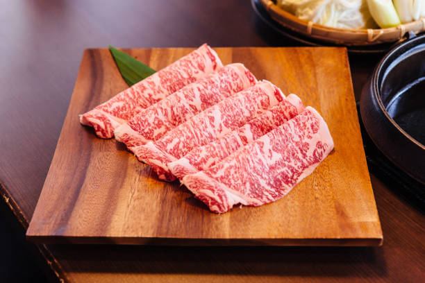 Premium Rare Slices Wagyu A5 beef with high-marbled texture on square wooden plate served for Sukiyaki and Shabu. Premium Rare Slices Wagyu A5 beef with high-marbled texture on square wooden plate served for Sukiyaki and Shabu. marbled meat stock pictures, royalty-free photos & images