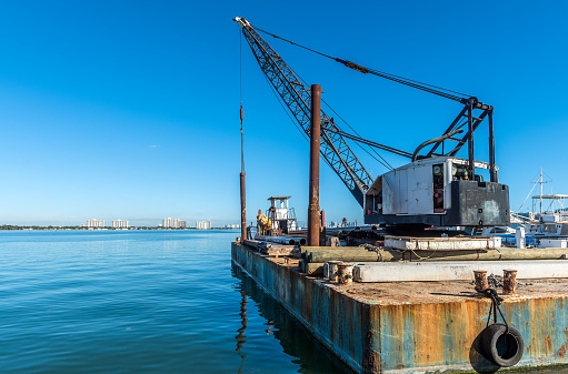 Crane barge doing marine heavy lift in a Miami Beach marina, Florida.