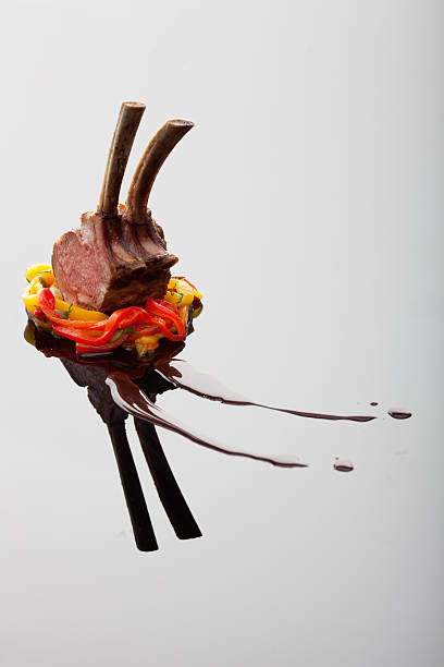 Gorgeous artistically arranged rack of lamb waiting to be eaten, vertical composition on a reflective surface