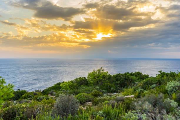 istock Greece, Zakynthos, Romantic orange sky as sun breaks through clouds at island coast 1091809672