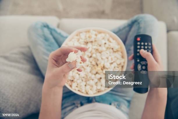 High Angle Above Top View Close Up Cropped Pow Overhead First Person Photo Of Spectator Lady With Her Brunette Hair Box Of Corn She Sit In Comfort Modern Light House Hold Snack And Remote Control Stock Photo - Download Image Now