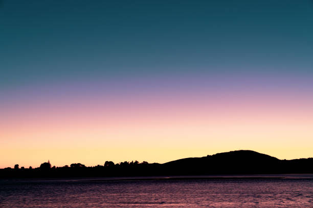 Retro faded effect of intense colors of sunrise sky while sun remains below horizon, background and travel image.
