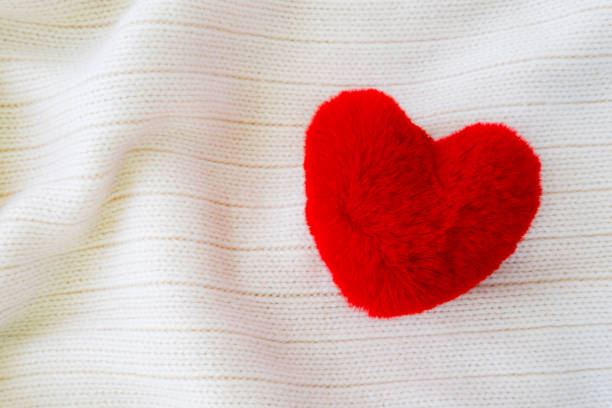 istock Fluffy red thread heart on white soft cozy fabric background. 1091825588