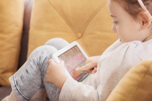 istock Cute little girl using a digital tablet 1091825998