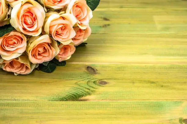 Photo of Roses bouquet on wooden table. Flowers background for mother's day card.