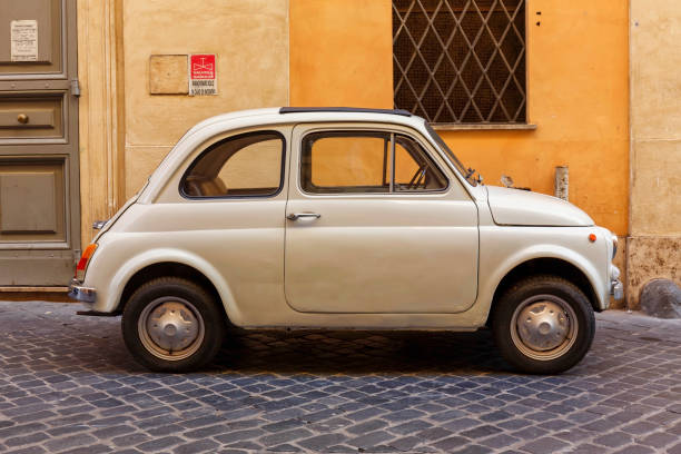 View of a beige Fiat 500 Cinquecento parked on a street in central Rome at day Rome, Italy - October 09, 2018: View of a Fiat 500 Cinquecento parked on a street in central Rome at day little fiat car stock pictures, royalty-free photos & images