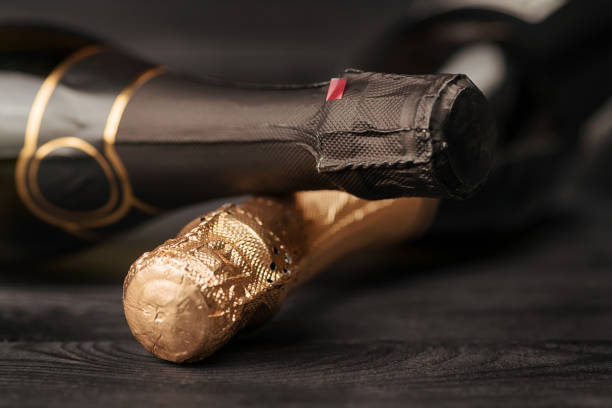 Two champagne bottles on black wooden table