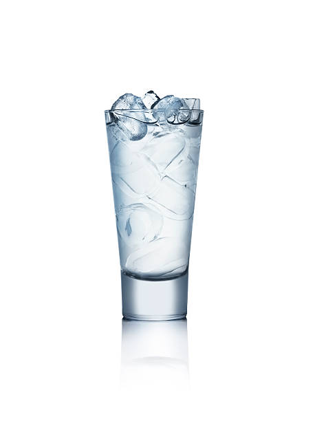 Close up of glass of water with ice on a wooden table.