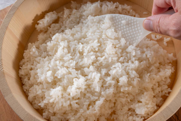 Steamed white rice in wooden mixing container