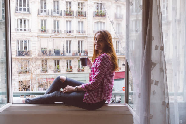 istock Relaxed woman in Paris drinking coffee at the window 1091841528