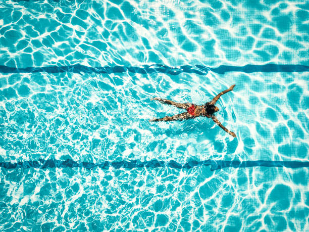 수영장에서 빨간 비키니에 있는 여자에 오버 헤드 보기 - 평영 뉴스 사진 이미지