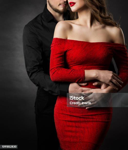 Couple Fashion Beauty Woman In Red Dress And Embracing Man In Love Stock Photo - Download Image Now