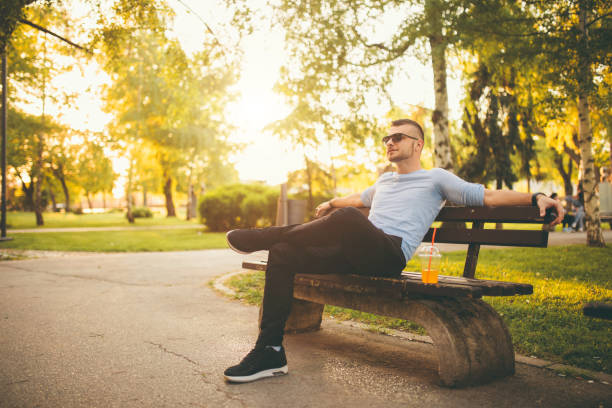 istock Man sitting on a bench in the park 1091854452