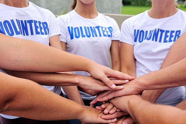 voluntarios grupo de las manos juntas - youth organization fotografías e imágenes de stock