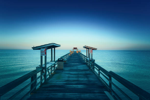Pier in Naples, Florida Early bird picture of the end of the Naples Pier in Florida naples beach stock pictures, royalty-free photos & images