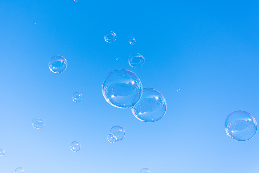 Soap bubble fly on blue sky background