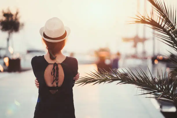 Photo of Woman on beach holiday watching the sunset