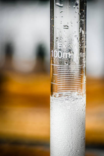 Clear bubbly liquid in a beaker or test tube with lines of demarkation, measuring the volume of liquid in milliliters, macro photography, close up science, medicine or STEM experiment, science project or scientific development