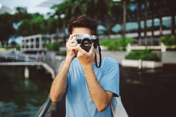 istock young tourist man in Singapore taking phots with a retro styled camera 1091875680
