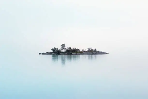 Photo of Remote Island Hanging In The Fog Over The Northern Lake