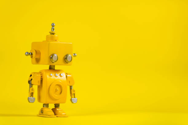 roboter auf einem gelben hintergrund. - cyborg fotos stock-fotos und bilder