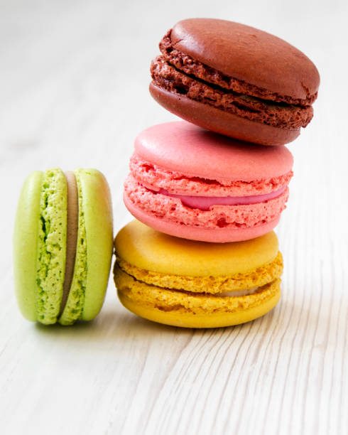 istock Colorful macaroons on a white wooden table, side view. Close-up. 1091885966