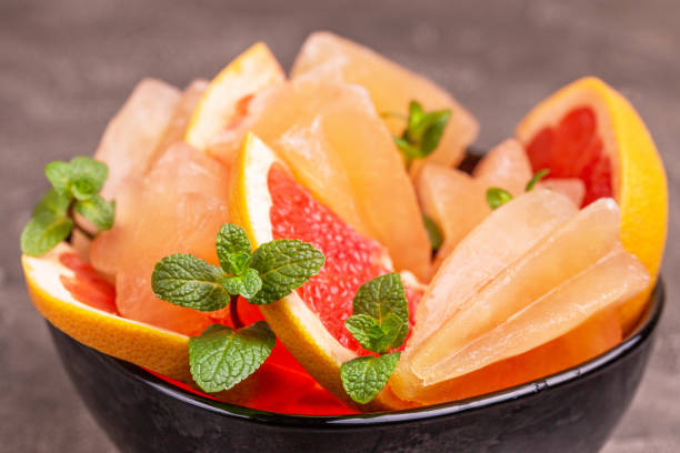 istock Homemade grapefruit popsicle with ripe grapefruit slices and fresh mint on dark concrete background 1091888830