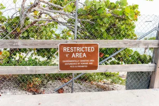 Old Bahia Honda Bridge Trail in state park during day in Florida Keys, with hiking path, sign for restricted area on fence