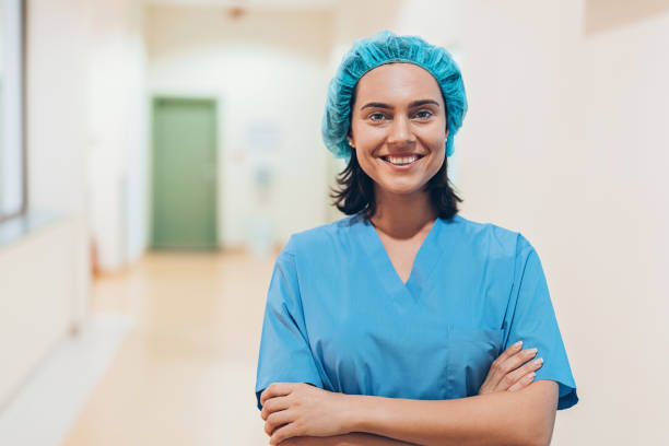 Nurse standing in a medical clinic corridor Portrait of a smiling female medical worker midwife photos stock pictures, royalty-free photos & images