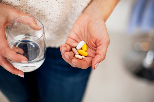 istock Female holding vitamins and water 1091896392