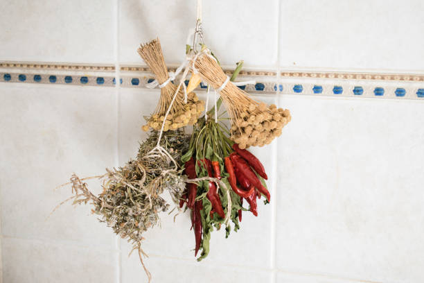 Dried herb bundles and red peppers hanging on the wall