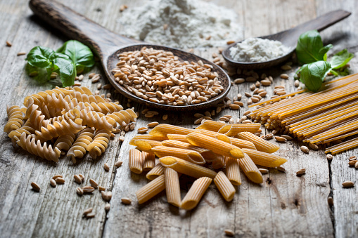 Close-up of raw spelt, flour and dinkel pasta