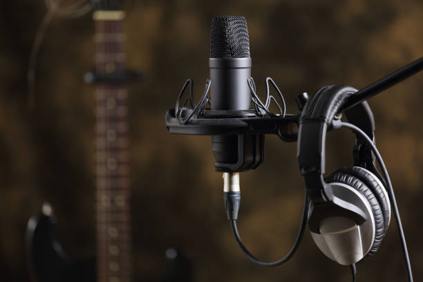Composition with the studio microphone, earphones and an electric guitar