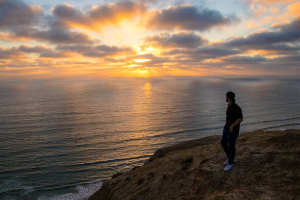 istock Young man watching a Pacific Coast sunset at Torrey Pines near La Jolla 1091920760