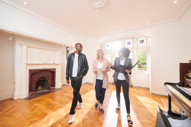 estate agent housebuying viewing an estate agent shows a couple around a refurbished period home salesman photos stock pictures, royalty-free photos & images