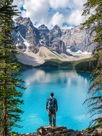 Hiker looking at view at Moraine Lake in Banff National Park, Canadian Rockies, Alberta, Canada.