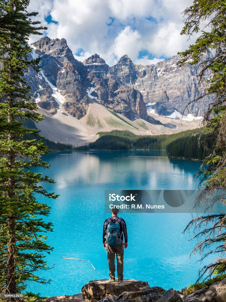 Hiker at Moraine Lake in Banff National Park, Alberta, Canada Hiker looking at view at Moraine Lake in Banff National Park, Canadian Rockies, Alberta, Canada. Hiking Stock Photo