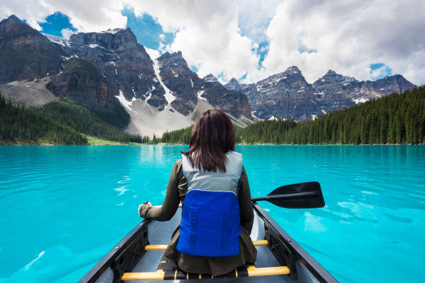 Tourist Canoeing on Moraine Lake, Banff National Park, Alberta, Canada Tourist canoeing on Moraine Lake in Banff National Park, Canadian Rockies, Alberta, Canada. kayaking banff stock pictures, royalty-free photos & images
