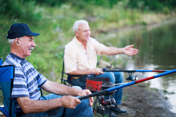 Two men relaxing and fishing Two men relaxing and fishing. Active seniors. grill rods stock pictures, royalty-free photos & images