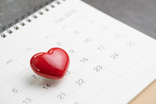 Love symbol or romance of valentine's day concept with shiny red lovely heart shape on 14 Feb white clean calendar.