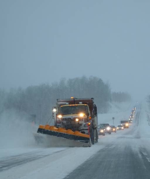 schneepflug triebschnee straße in böen mit spuren von autos nach umzug - plow stock-fotos und bilder