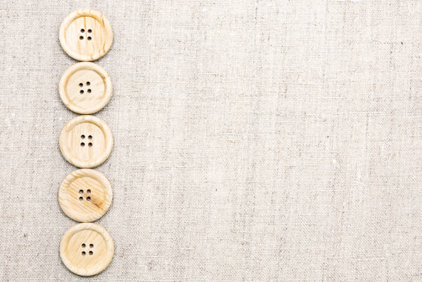 grandi bottoni da cucito in legno con quattro fori su tessuto naturale di lino - plastic hole heap close up foto e immagini stock
