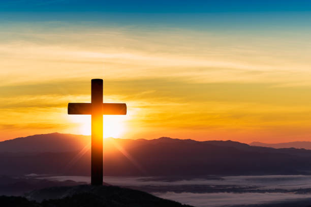 istock Silhouette of cross on mountain sunset background. 1092001096